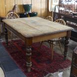 A large late 19th or early 20thC pine plank top Kitchen Table, the rectangular top with rounded