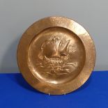 An Arts & Crafts copper Charger, of circular form, with embossed sailing ship decoration, 41cm