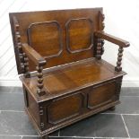 A Victorian oak Monk's Bench, of typical box form, the sliding top raised on turned column supports,