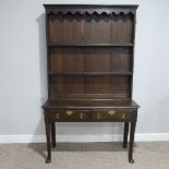 An early 19th century oak dresser with plate rack, with shaped cornice and two shelves above two