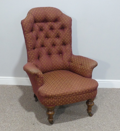 A Victorian upholstered button-back Armchair, raised on turned legs and casters, some woodworm, W