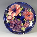 A Moorcroft 'Anenome' pattern Plate, tube lined decoration on cobalt blue ground, factory marks to