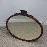 An Edwardian mahogany cushion framed oval Wall Mirror, with bevelled plate, 84cm x 64cm.