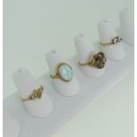 Four 9ct yellow gold Rings; one set oval opal, one smokey quartz, one a crossover with white pastes,