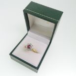 A ruby and diamond cluster Ring, the central facetted oval ruby, approx. 0.45ct, claw set above a