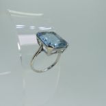 An aquamarine Dress Ring, the emerald cut stone 13.5mm x 11.6mm, mounted in unmarked white metal,