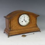 An early 20thC inlaid oak Mantle Clock, the central enamel dial flanked by gilt metal columns,