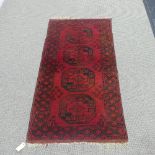 Tribal rugs; a red ground hand-knotted Afghan rug, 100 % wool, woven with with four large Tekke, L