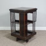 An Edwardian Revolving Bookcase, of two tier four section form, raised on an X framed base, on