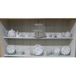 A Minton 'Haddon Hall' pattern Tea Service, comprising Teapot, Jugs, eleven Cups and Saucers,