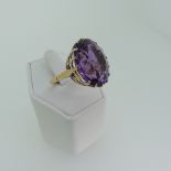 A large amethyst Dress Ring, the oval facetted stone approx. 20x16mm, claw set in 15ct gold, Size