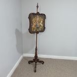 A Victorian mahogany tapestry Pole Screen, with turned column on carved tripod base, the tapestry