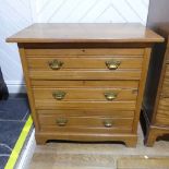 An Edwardian satinwood Chest of Drawers, comprising three long drawers with brass handles, raised on
