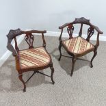 A pair of Edwardian upholstered Corner Chairs, with foliate carved backs, on cabriole legs joined by