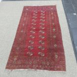 Tribal rugs; a red ground hand-knotted Afghan rug, 100 % wool, woven with two rows of ten Tekke, L