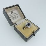 A sapphire and diamond cluster Ring, the central circular facetted sapphire, c. 5.6mm diameter, claw