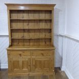 An antique pine kitchen Dresser, with moulded cornice above a three tier plate rack, with two