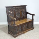 A Victorian carved oak box seat Settle, with panelled back and hinged seat, W 109cm x D 54cm x H