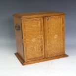 An early 20thC inlaid oak two door Smokers Cabinet, the double doors inlaid with rosettes