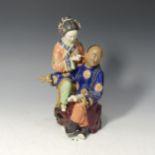 A 20thC Chinese porcelain Figure of a woman piercing a gentleman, decorated in rich enamels, with