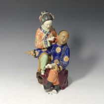 A 20thC Chinese porcelain Figure of a woman piercing a gentleman, decorated in rich enamels, with