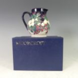A Moorcroft 'Snowberry' pattern Jug, with tube lined decoration on cream/ blue ground, with