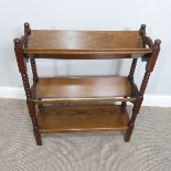 An Arts and Crafts oak three-tier Book Trough, with bobbin-turned supports and pierced with heart-