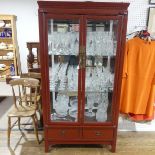 A modern oriental mirror-back Display Cabinet, with two glazed doors enclosing shelves, above two