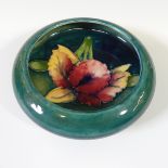 A Moorcroft small circular Dish, tubelined floral decoration on green ground, factory marks to base,