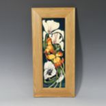 A Moorcroft 'Miss Alice' pattern framed Plaque, tube lined decoration on green ground, designed by