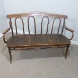 An early 20thC Thonet bentwood Settle, with shaped back and arm rests, raised on tapering legs,