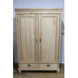 An antique pine double Wardrobe, with panel doors and two drawers, on fluted feet, W:125 x H:186 x