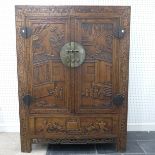 A Chinese carved hardwood Wedding Cabinet, the heavily carved double doors opening to reveal an