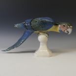 A Royal Dux porcelain model of a Parrot, modelled perched upon a finial, underglaze decoration, with