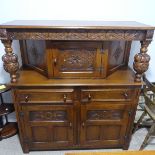 An antique style carved oak Court Cupboard,  the top with carved supports, flanking the central