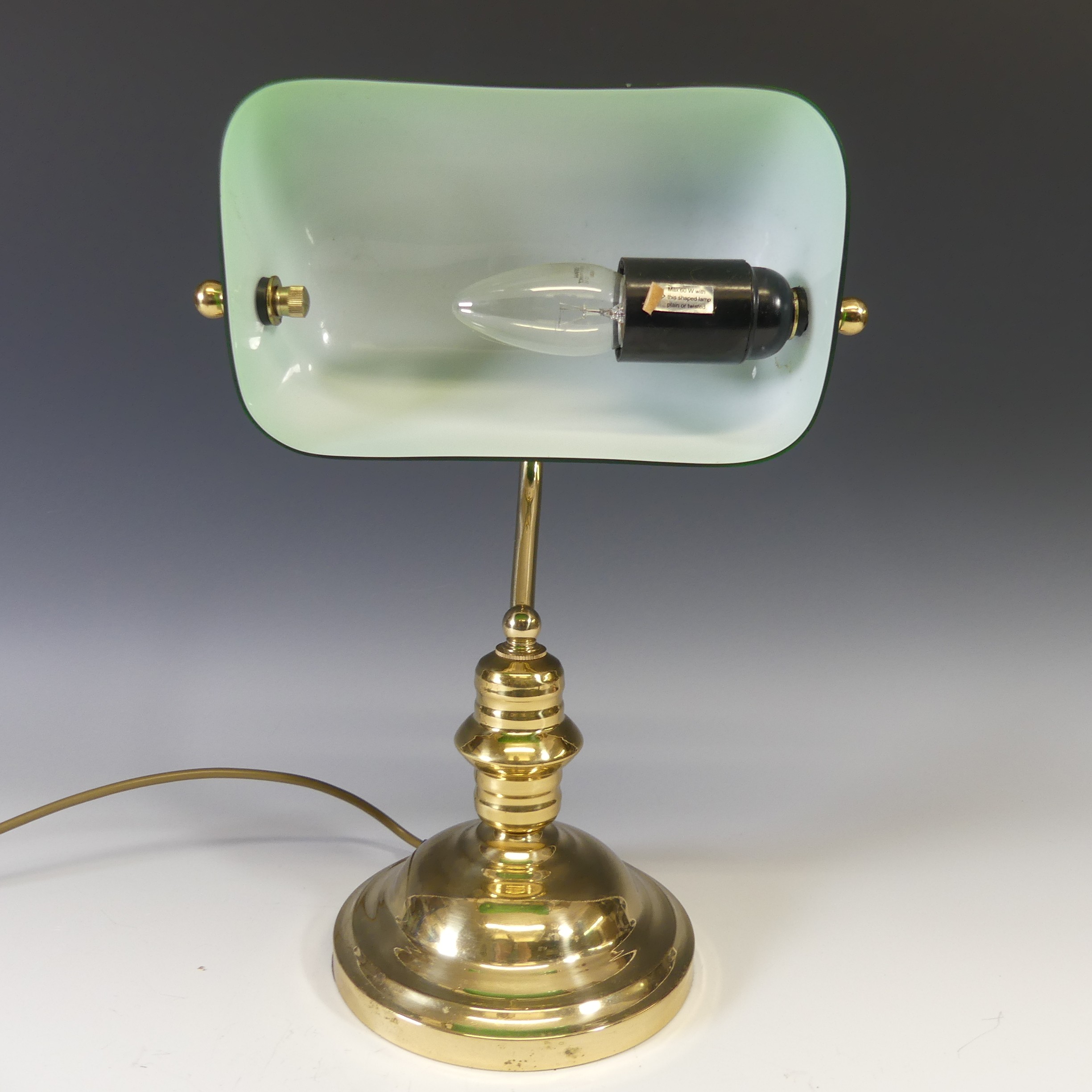 A vintage 20thC desk Lamp, having a brass base with green glass rectangular shade, H 37cm.