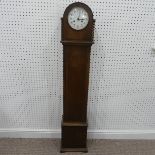 An 1930's oak Granddaughter Clock, with circulat dial and Arabic numerals, the brass English