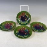 A set of four Moorcroft 'Finch' pattern Coasters, with tubelined decoration on green ground, factory