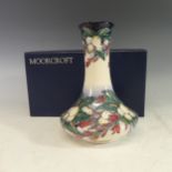 A Moorcroft 'Snowberry' pattern bottle Vase, tube lined decoration on cream and blue ground, with