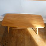 An Ercol blonde Elm and Beech 'Windsor' Coffee Table, of rounded rectangular form, with spindle rack