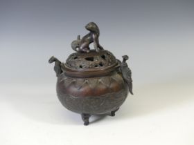 A 19th century oriental bronze twin-handle tripod Censer, with relief decoration depicting dragons