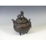 A 19th century oriental bronze twin-handle tripod Censer, with relief decoration depicting dragons