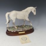 A Royal Doulton figure of Desert Orchid, raised on a wooden plinth, with certificate of