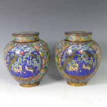 A pair of Japanese cloisonne lidded Jars, decorated with a panel depicting birds and mythical beasts