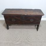 An 18th century oak Coffer, with iron lock plate, carved stylised lozenge to the front, on high