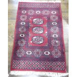 Tribal Rugs; A small red ground wool pile Bokhara Rug, 134cm x 80cm.