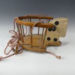 A vintage Triang wooden infants swing seat in the shape of a horse with traing label, handles and