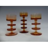 A pair of Wedgwood Sheringham pattern amber glass Candle Holders, designed by Ronald Stennett