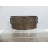 A Hugh Wallis Arts and Crafts copper Wine Cooler, with repousse stylised fruit and vines to side,