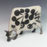 Lawson E. Rudge (b. 1936), a raku fired studio pottery sculpture of a Grazing Cow, with crackle